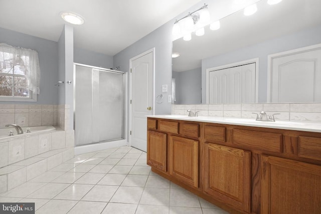 bathroom featuring plus walk in shower, vanity, and tile patterned floors