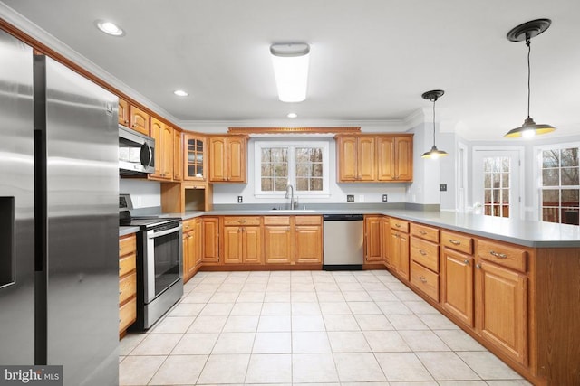 kitchen featuring kitchen peninsula, stainless steel appliances, crown molding, sink, and hanging light fixtures