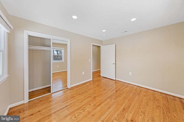 unfurnished bedroom with a closet and light hardwood / wood-style flooring