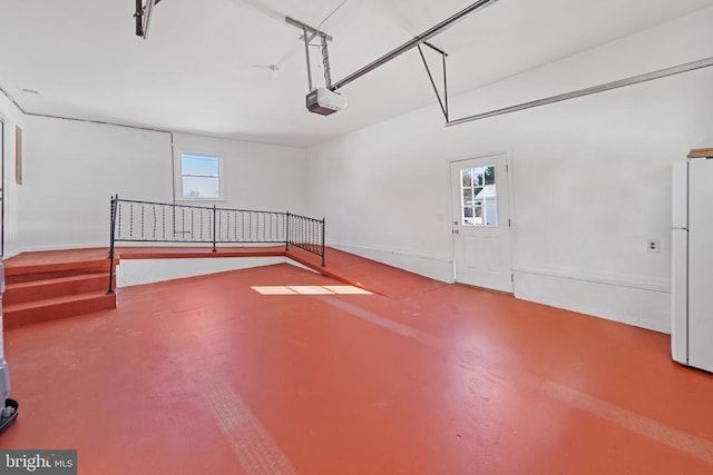 garage with white fridge and a garage door opener