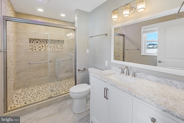 bathroom featuring vanity, toilet, and walk in shower