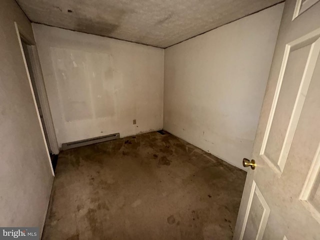 unfurnished room featuring concrete flooring and baseboard heating