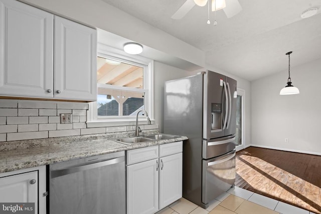 kitchen featuring ceiling fan, sink, stainless steel appliances, white cabinets, and light tile patterned flooring