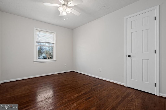 spare room with ceiling fan and dark wood-type flooring