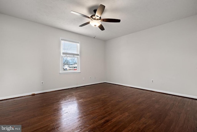 spare room with ceiling fan and dark wood-type flooring