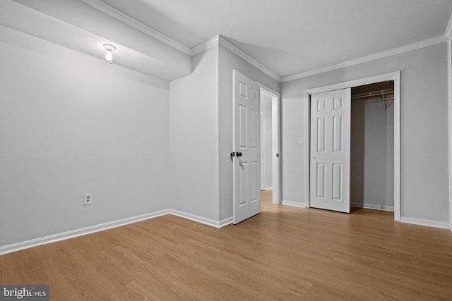 unfurnished bedroom with light hardwood / wood-style floors, crown molding, and a closet