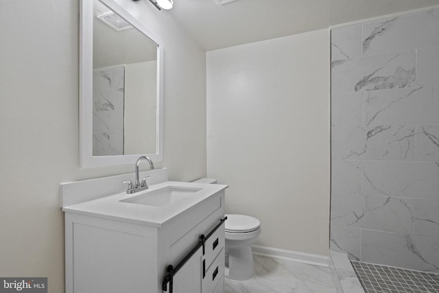 bathroom with vanity, toilet, and a tile shower