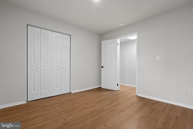 unfurnished bedroom with light hardwood / wood-style floors and a closet