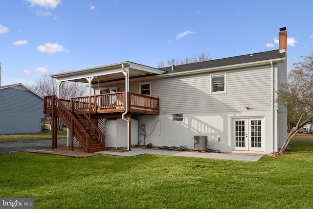 rear view of property featuring french doors, central air condition unit, a lawn, and a wooden deck