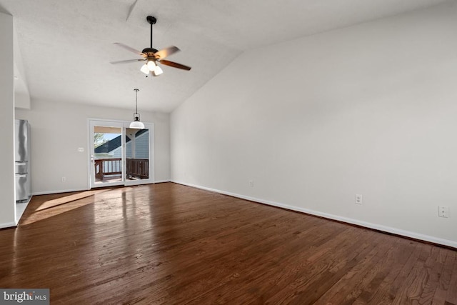 unfurnished living room featuring dark hardwood / wood-style flooring, vaulted ceiling, and ceiling fan