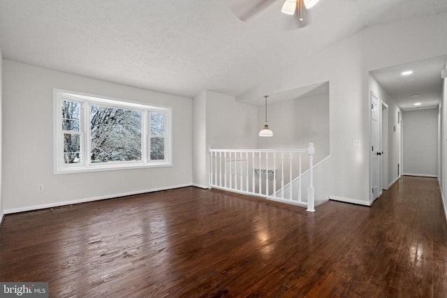 spare room featuring dark hardwood / wood-style floors, ceiling fan, and lofted ceiling