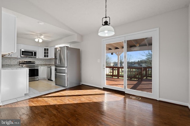 kitchen with appliances with stainless steel finishes, backsplash, ceiling fan, decorative light fixtures, and white cabinetry