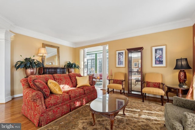 living room with hardwood / wood-style floors, ornate columns, and crown molding