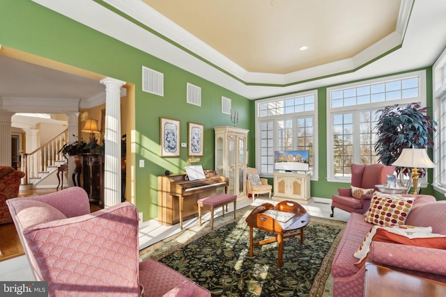 interior space featuring crown molding, a tray ceiling, and decorative columns