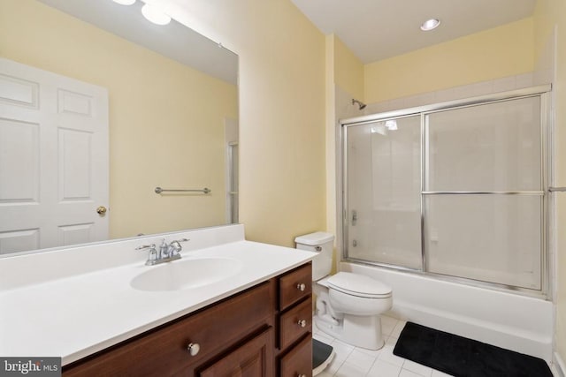 full bathroom with tile patterned floors, shower / bath combination with glass door, vanity, and toilet