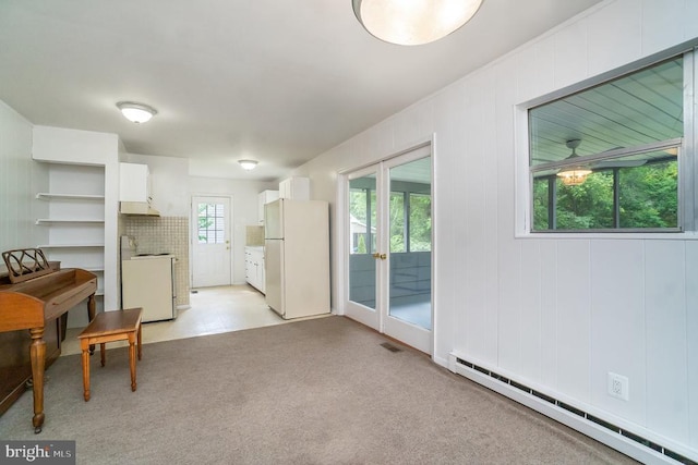 interior space with white cabinetry, french doors, a baseboard heating unit, stove, and white fridge