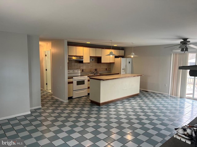 kitchen with decorative backsplash, white appliances, sink, pendant lighting, and a kitchen island