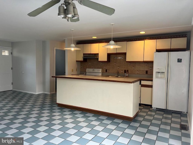 kitchen featuring white fridge with ice dispenser, sink, stove, pendant lighting, and decorative backsplash