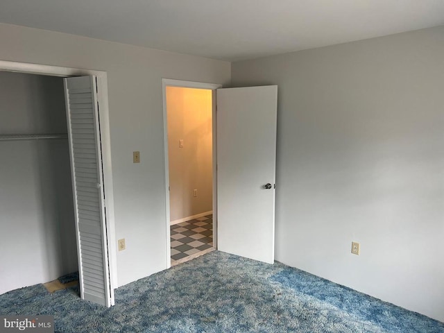 unfurnished bedroom with a closet and carpet floors