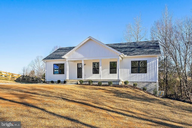 modern farmhouse style home with covered porch and a front yard