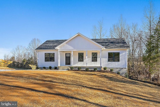 modern farmhouse style home featuring covered porch and a front lawn