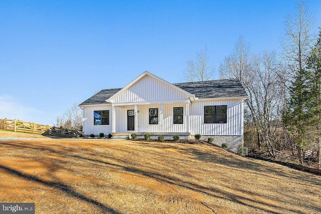 modern inspired farmhouse featuring a front lawn and covered porch