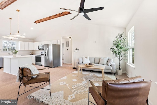 living room with ceiling fan, beamed ceiling, high vaulted ceiling, and light wood-type flooring