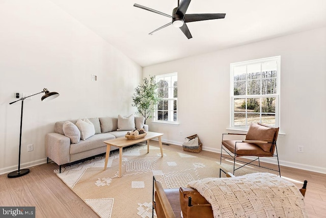 living room with ceiling fan, light hardwood / wood-style flooring, and vaulted ceiling