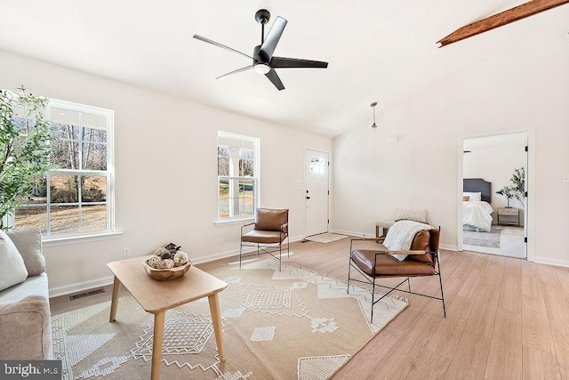 living room featuring lofted ceiling with beams, light hardwood / wood-style floors, and ceiling fan