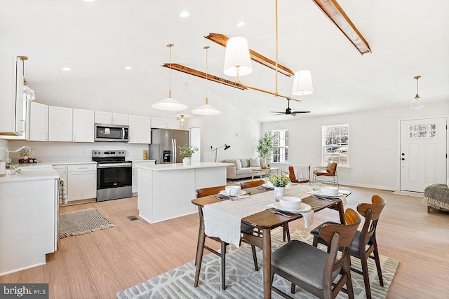 dining area with ceiling fan, light hardwood / wood-style floors, sink, and high vaulted ceiling