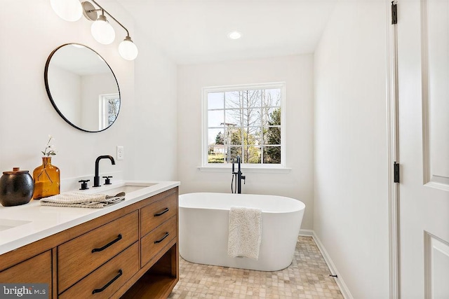 bathroom with a tub to relax in and vanity