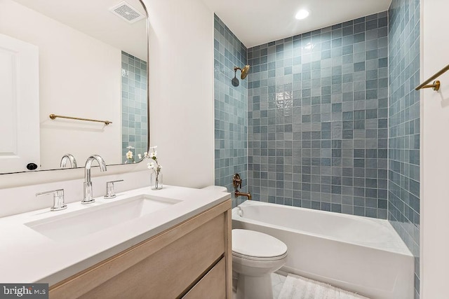 full bathroom with vanity, tiled shower / bath combo, and toilet