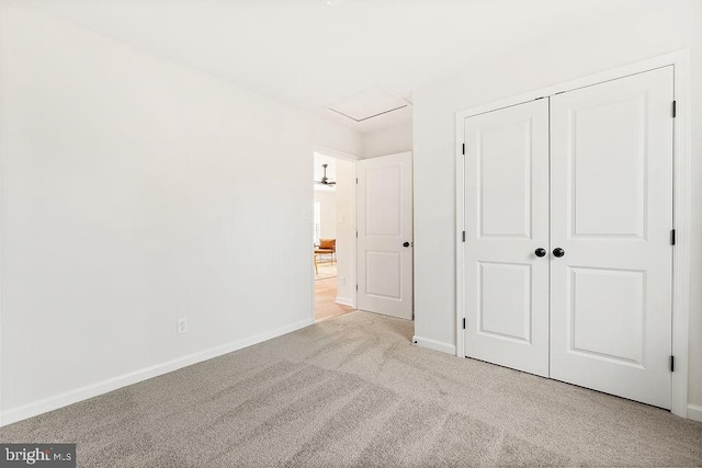 unfurnished bedroom featuring a closet and light colored carpet