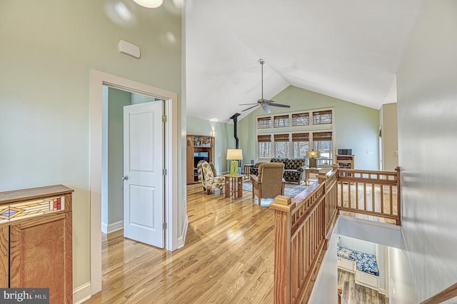 kitchen with ceiling fan, light wood-type flooring, and high vaulted ceiling