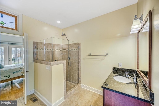 bathroom with tile patterned floors, vanity, a shower with shower door, and french doors