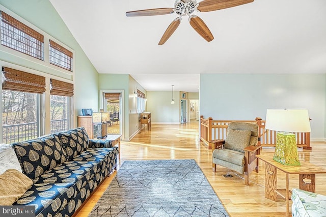 living room with light wood-type flooring, ceiling fan, and lofted ceiling