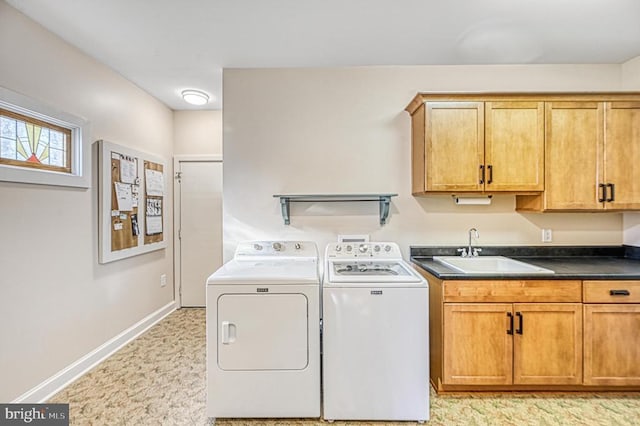 laundry room featuring separate washer and dryer, sink, and cabinets