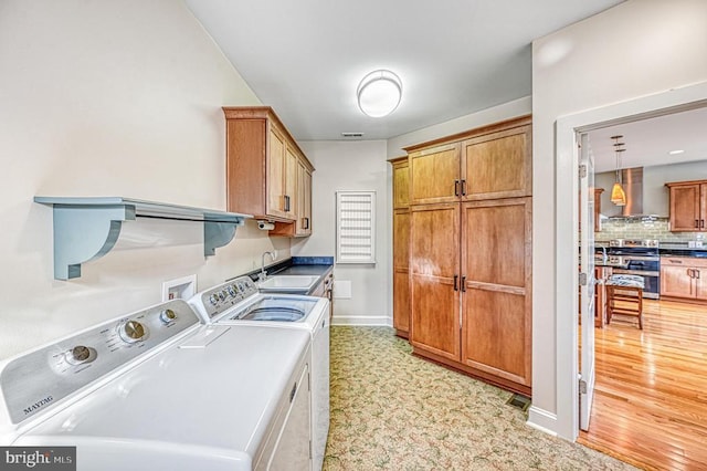 washroom featuring separate washer and dryer, sink, and cabinets