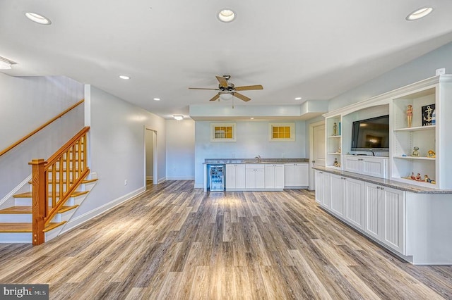 kitchen featuring beverage cooler, ceiling fan, sink, light hardwood / wood-style floors, and white cabinetry