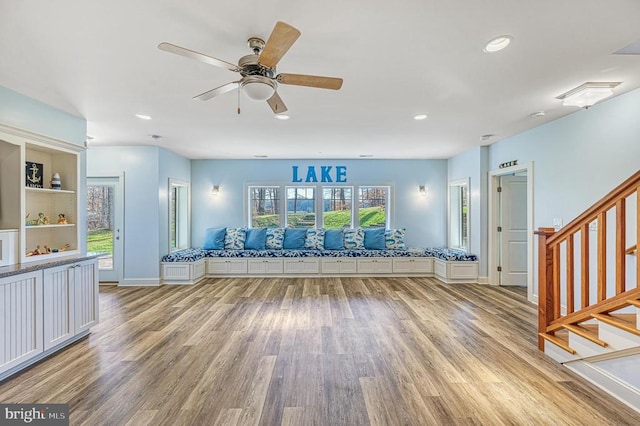 exercise area featuring hardwood / wood-style floors, ceiling fan, and built in shelves