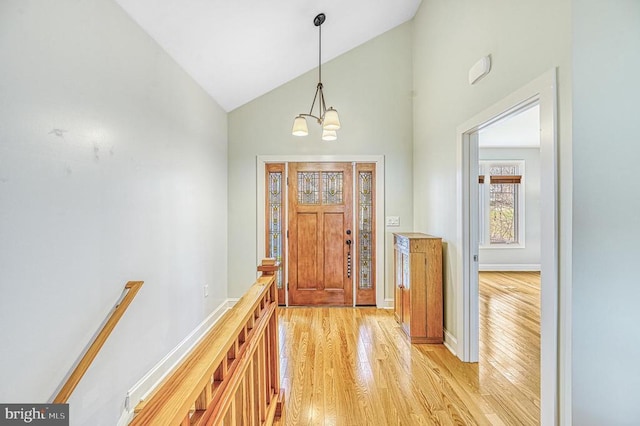 interior space featuring light wood-type flooring, high vaulted ceiling, and an inviting chandelier