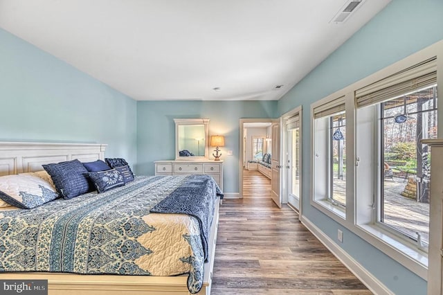 bedroom with hardwood / wood-style floors and access to outside