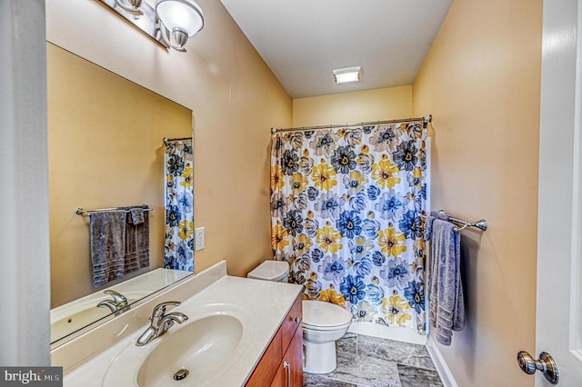 bathroom featuring vanity, curtained shower, and toilet