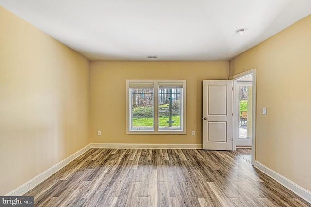 empty room with hardwood / wood-style flooring and a healthy amount of sunlight