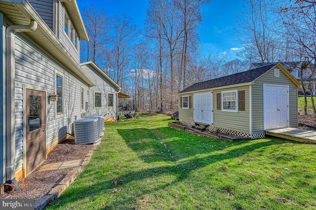 view of yard with central AC unit and an outbuilding