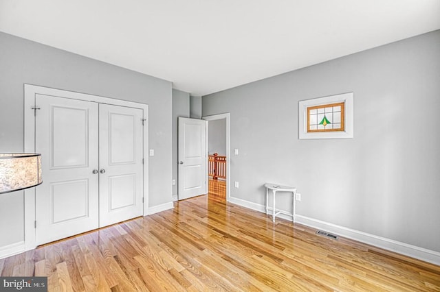 unfurnished bedroom featuring light hardwood / wood-style floors and a closet