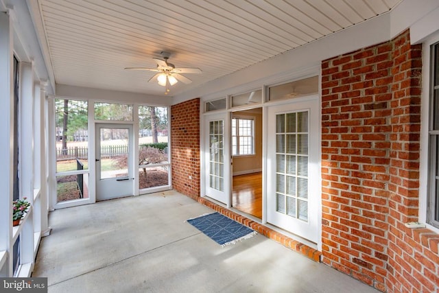 unfurnished sunroom featuring ceiling fan