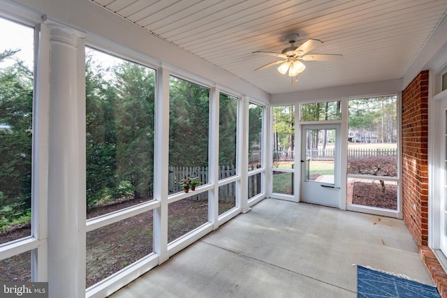 unfurnished sunroom featuring ceiling fan and a wealth of natural light