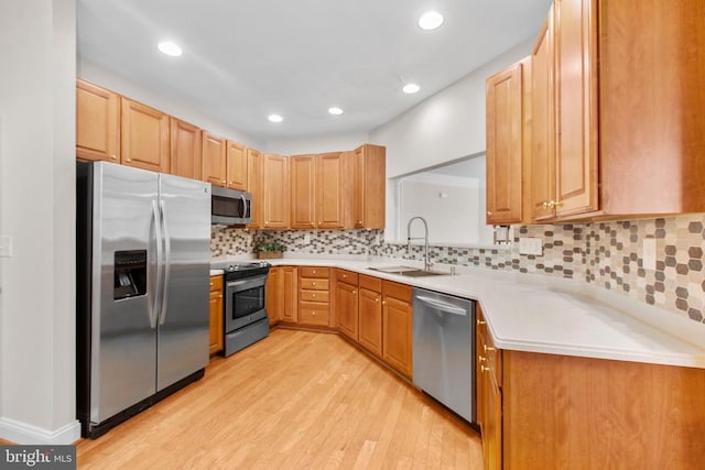 kitchen featuring tasteful backsplash, sink, stainless steel appliances, and light hardwood / wood-style floors