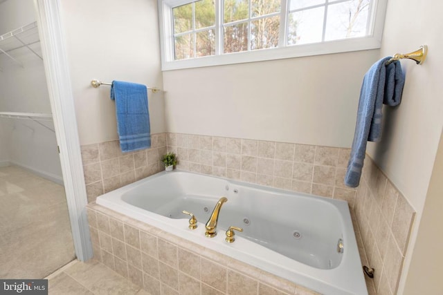 bathroom with tiled bath, tile patterned floors, and a wealth of natural light